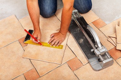 installing ceramic floor tiles - measuring and cutting the pieces, closeup