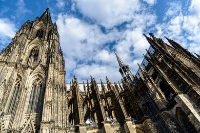 image displaying the wonderful architectural detail of cologne cathedral against a blue sky