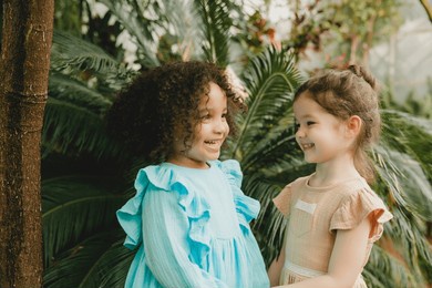 two cheerful little girls in the botanical garden. spring summer.