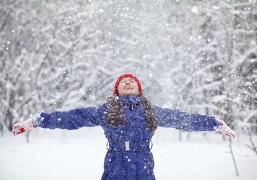 portrait of a girl walking in the winter outdoors. playing with snow. children outdoor