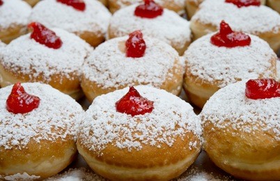 fresh donuts with jam in the bakery for hanukkah celebration.