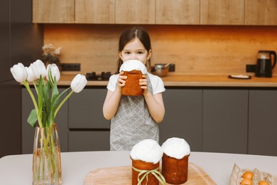 little girl sitting at the table with easter cookies. christ is risen. homemade baking for the holidays, healthy food.