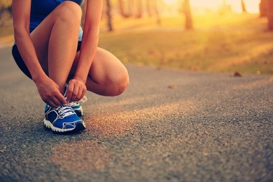 young woman runner tying shoelaces 