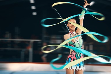 ribbon dancing, portrait and happy woman in gymnastics competition, talent show and dark mockup arena. female dancer, rhythmic movement and smile for action, creative performance and sports concert