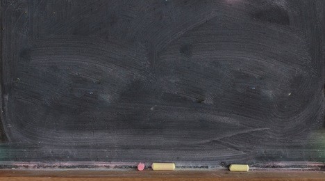 blank blackboard with colored chalks