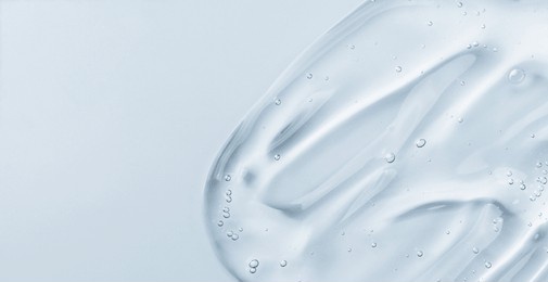 serum gel smear on blue background. cosmetic transparent gel serum texture.