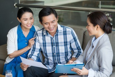 vietnamese couple and saleswoman discussing contract