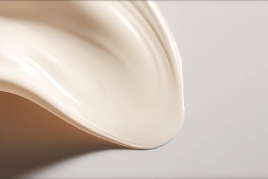 liquid foundation strokes on light color background, makeup creamy texture, skin tone cosmetic product smear smudge swatch
