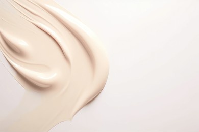liquid foundation strokes on light color background, makeup creamy texture, skin tone cosmetic product smear smudge swatch