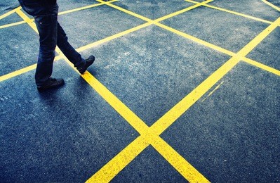 man walk on wet asphalt street with marked yellow lines. 