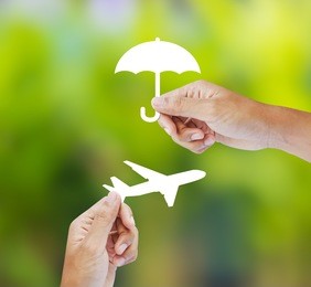 hand holding paper on green background, travel insurance