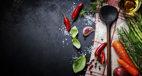 wooden spoon and ingredients on dark background. vegetarian food, health or cooking concept.