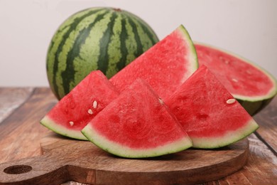 juicy ripe cut and whole watermelons on wooden table, closeup