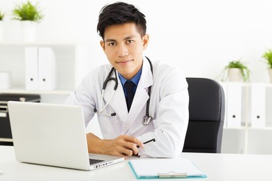 young asian doctor working with laptop in office