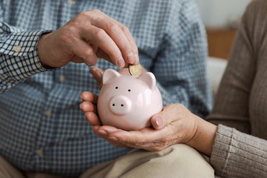 saving money investment for future. senior adult mature couple hands putting money coin in piggy bank. old man woman counting saving money planning retirement budget. saving investment banking concept