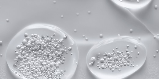 splashing of hyaluron gel. liquid hyaluronic acid gel on macro. hyaluronic acid cosmetic gel. bubbles gel texture on skin black background. textured background with oxygen bubbles. skin care product