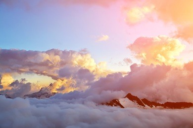 alpine landscape with peaks covered by snow and clouds. natural mountain background