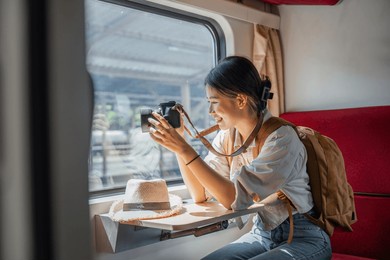 beautiful asian female tourist with sitting and take a photo travel location and sightseeing urban window view, public train transport, city lifestyle journey by railway