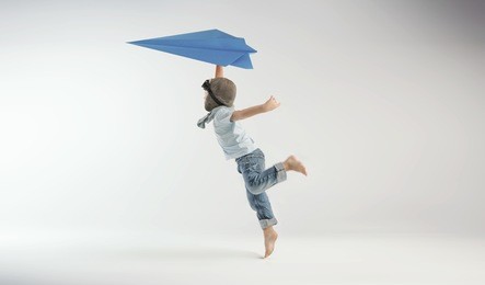 happy kid playing with toy airplane