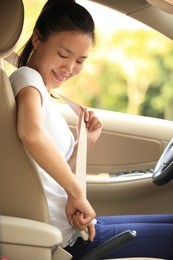woman driver buckle up the seat belt driving car 