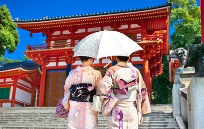  japanese girls with japanese traditional suit (yukata) are walking in the yasaka-jinja  shrine in kyoto, japan.