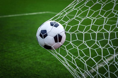 soccer ball on goal with net background, football player shoot a leather foot ball for make a score