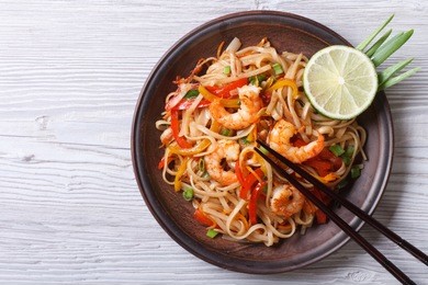 rice noodles with shrimps and vegetables close-up on the table. top view of a horizontal