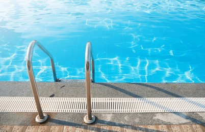 grab bars ladder in the blue swimming pool