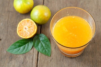 fresh orange juice with sliced fruit on the wood background