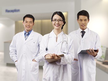 asian medical team standing in hospital lobby.