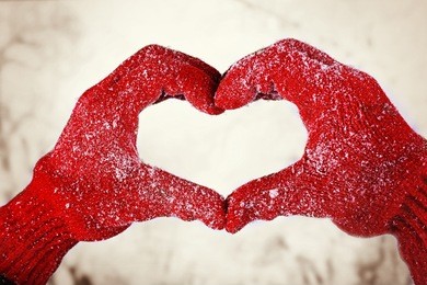 woman's hands in red gloves on winter natural background