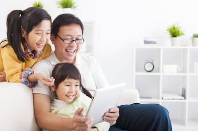 happy father using tablet pc with little girls