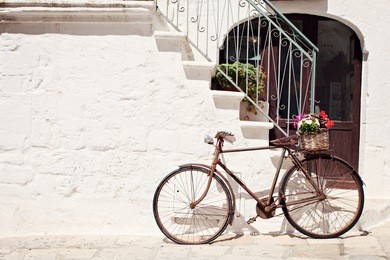old bicycle with a basket leaning against a wall in italy
