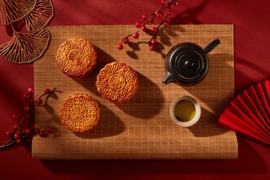 bamboo blinds featured a tea set in black color and three mooncakes with elegant patterns. tree branches decorated. mid autumn festival minimalist design