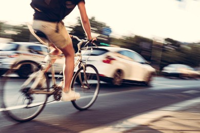 cycling in the city. man on bike in traffic, out of focus, motion blur. 