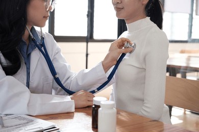 medical concept.the doctor is checking the patient pulse.health check.the doctor uses stethoscope to listen to the heart rate of the patient.