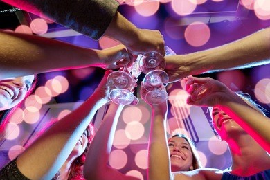 party, holidays, celebration, nightlife and people concept - smiling friends with glasses of champagne in club