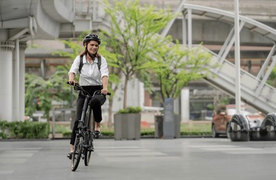 eco friendly, businesswoman ride bicycle in urban to reduce carbon footprint. beautiful woman environment preservation person commuting with bicycling. cycling, alternative transport for green energy.