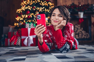 full body photo of cute lady video call friends waiting santa claus hold iphone send wishlist shopping isolated xmas tree background