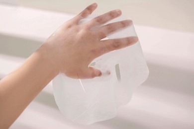 display with transparent facial mask cloth holding skin care products