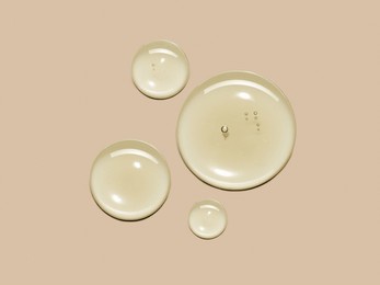 yellow serum oil sample swatch round shape texture isolated on beige background. cosmetic hyaluronic acid retinol collagen science lab product 