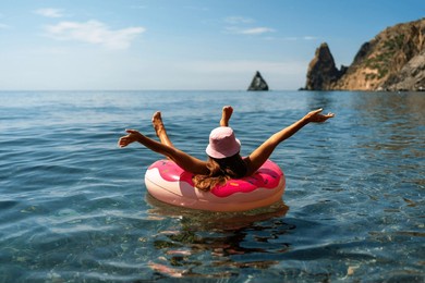 summer vacation woman in hat floats on an inflatable donut mattress. happy woman relaxing and enjoying family summer travel holidays travel on the sea.
