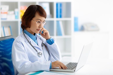 pensive doctor reading some information on the laptop screen