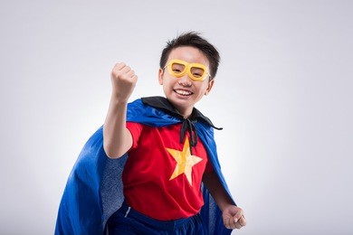 excited vietnamese boy wearing superhero costume