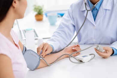 doctor checking blood pressure of the patient, selective focus