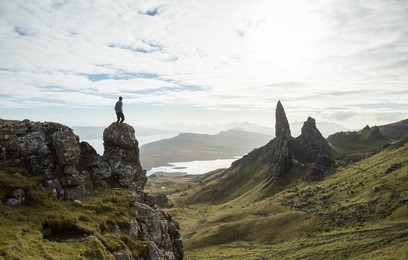 man vs nature, overlooking a stunning view of old rock pinnacle from a cliff top in the isle of skye, scotland. old man of storr.