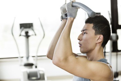 asian man relaxing after exercise in a gym.