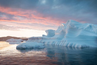 melting icebergs by the coast of greenland, on a beautiful summer day - melting of a iceberg and pouring water into the sea. global warming
arctic nature landscape, summer day