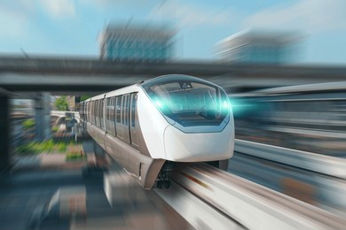 modern high speed monorail train with bright headlights passes race station on the stage through a tunnel at a road junction.