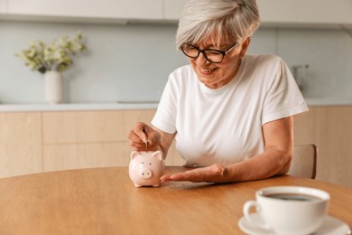 saving money investment for future. senior adult mature woman putting money coin in piggy bank. old grandmother counting saving money planning retirement budget. investment banking concept